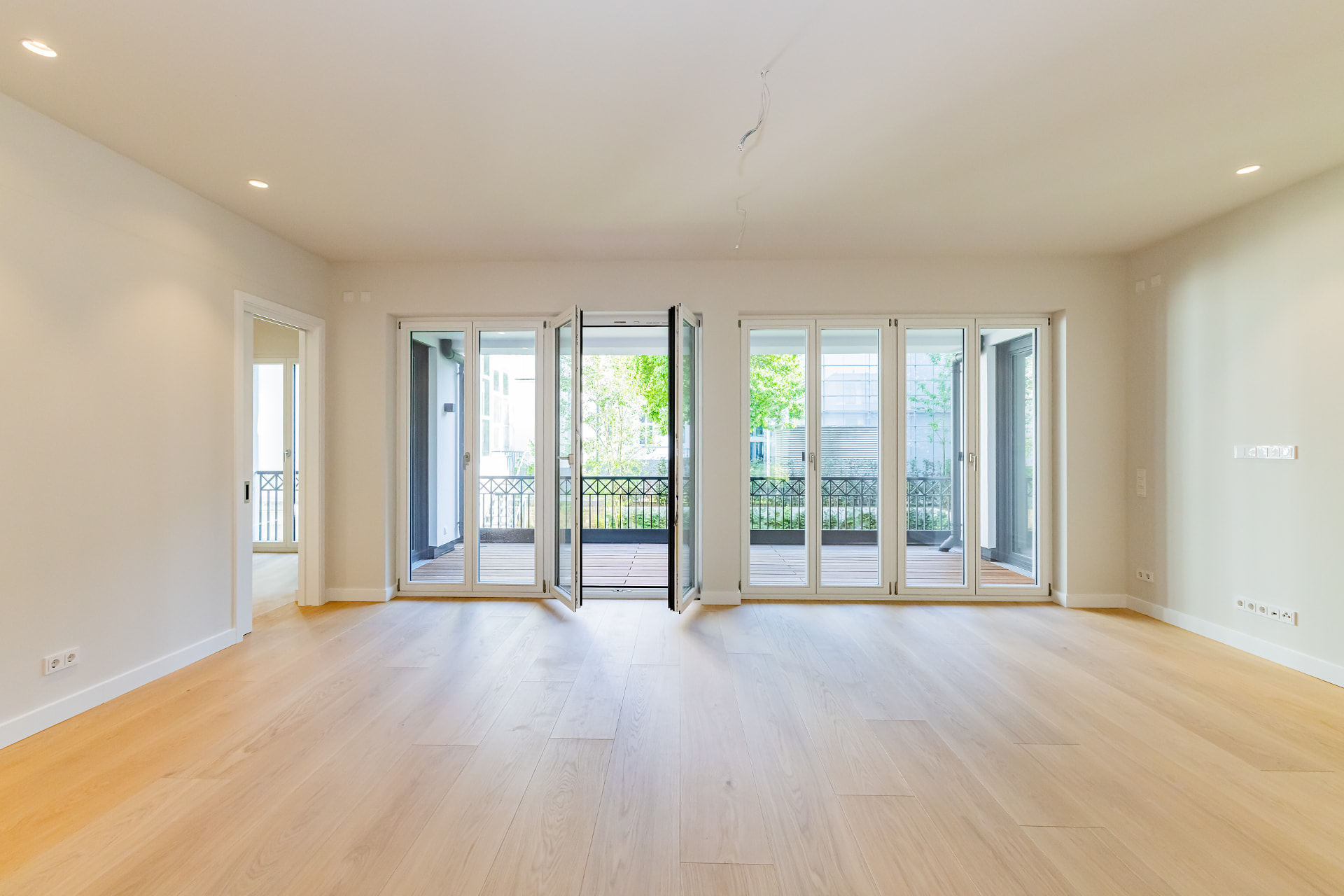 Wohnraum im 1. Obergeschoss mit bodentiefen Fenstertüren zur Balkonterrasse